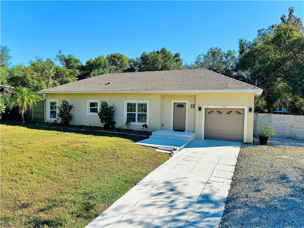 a front view of house with yard and trees in the background