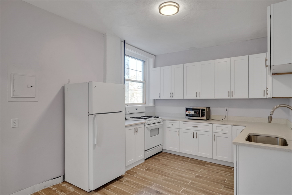 a kitchen with a refrigerator a sink and cabinets