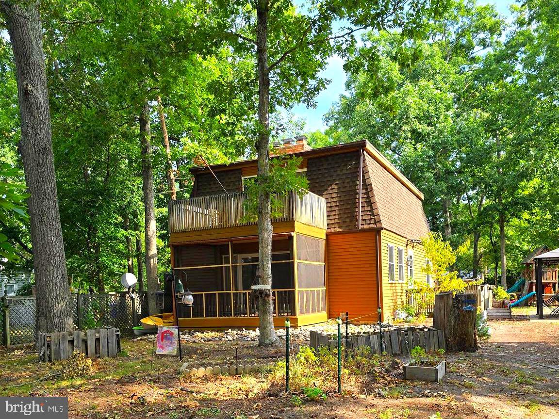 a front view of a house with a tree