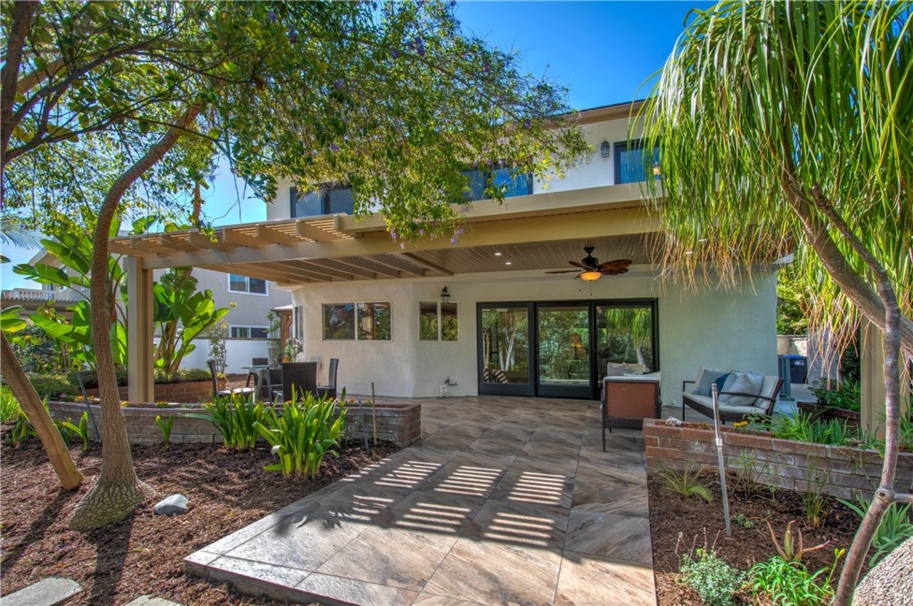 a view of a house with potted plants and a table and chairs