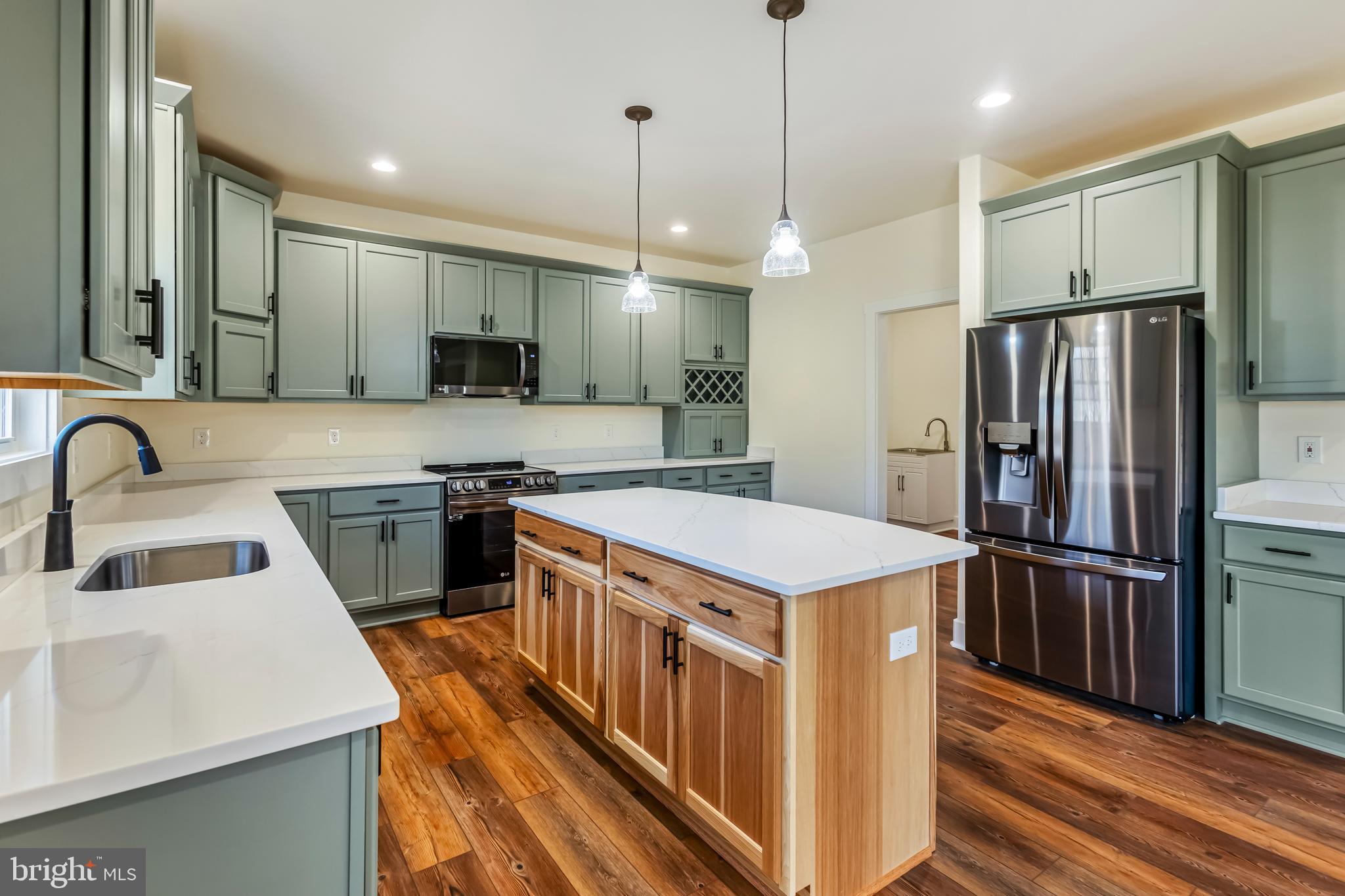 a kitchen with a refrigerator a sink and a stove top oven