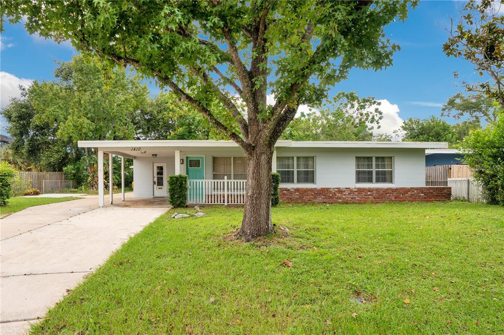 front view of a house and a yard with trees