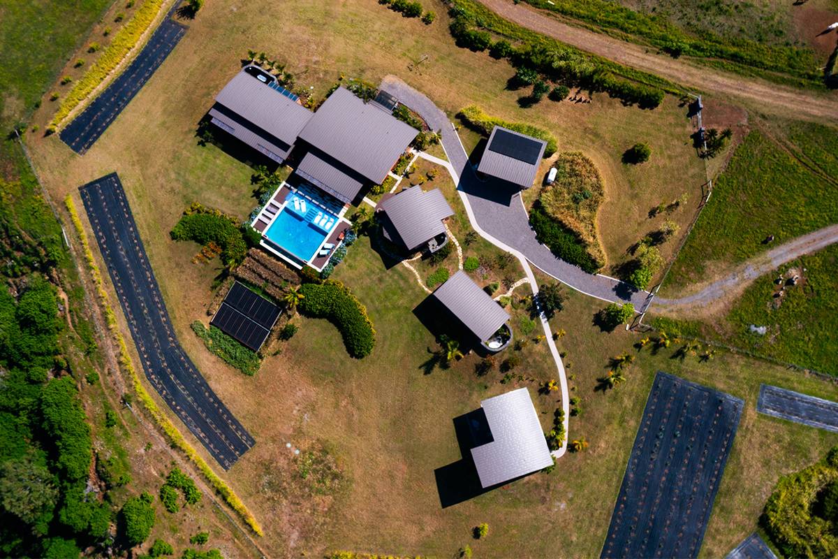 an aerial view of a house with a yard and wooden deck