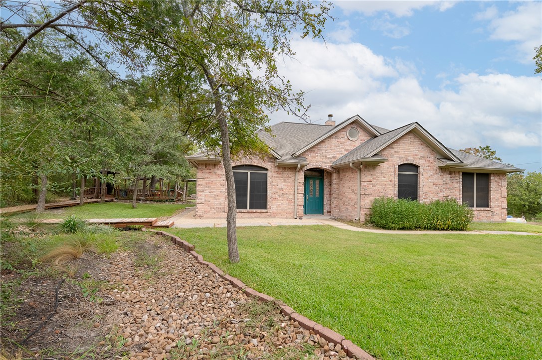 a front view of a house with yard and green space