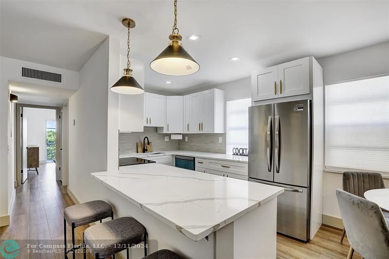 a kitchen with refrigerator cabinets dining table and chairs