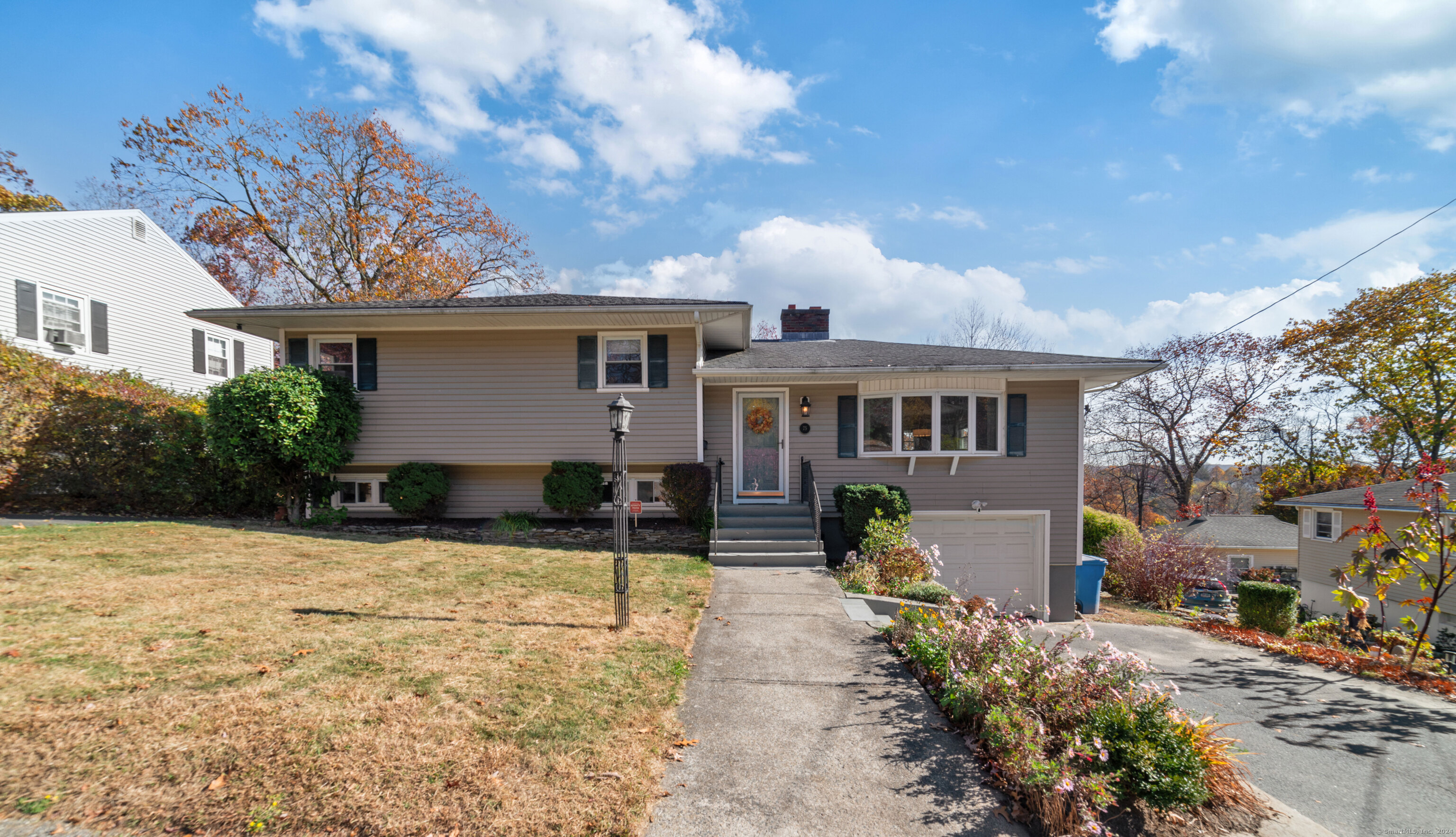 a front view of house with yard and trees in the background