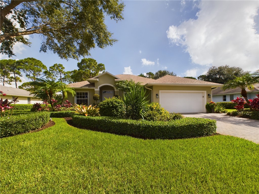 a front view of a house with a garden and yard