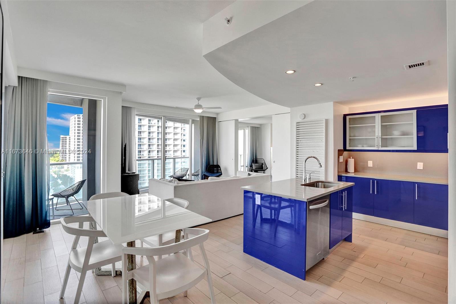 a large kitchen with kitchen island a sink table and chairs