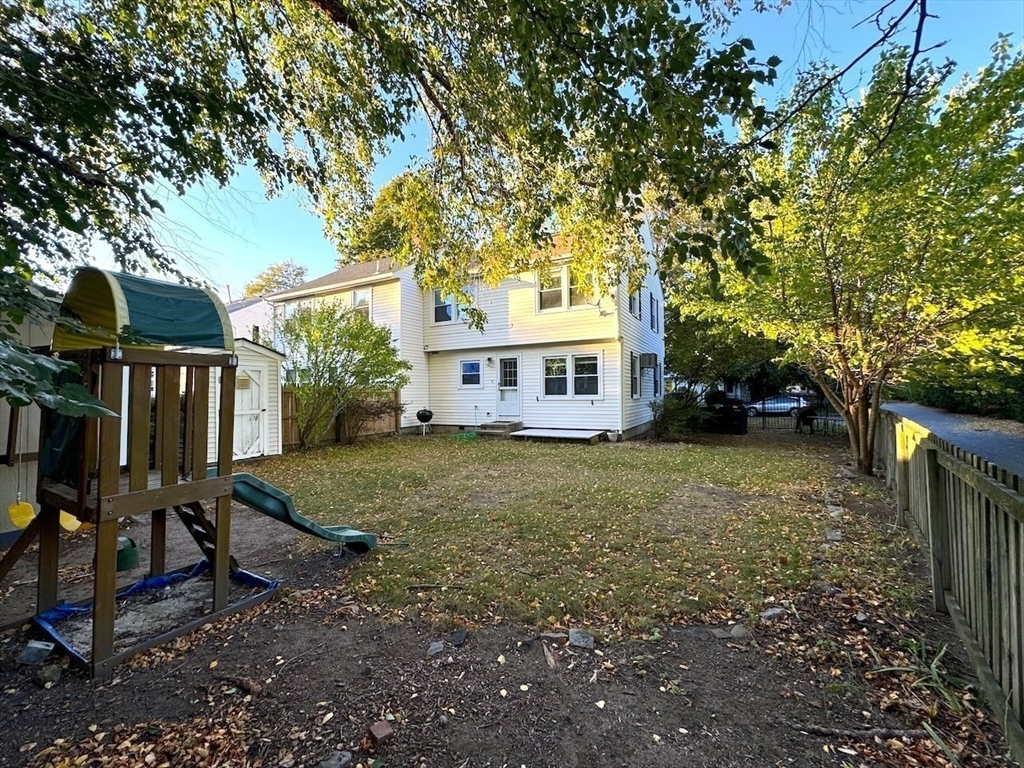 a view of a house with backyard and tree