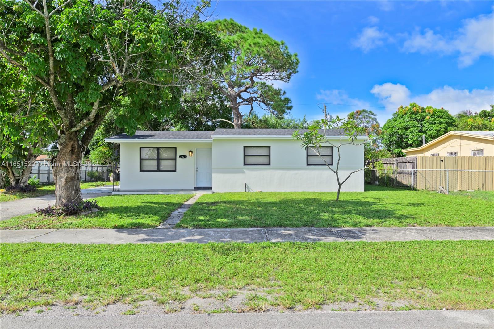 a view of a house with backyard and a tree