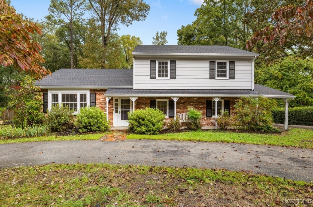 a front view of a house with a yard and trees