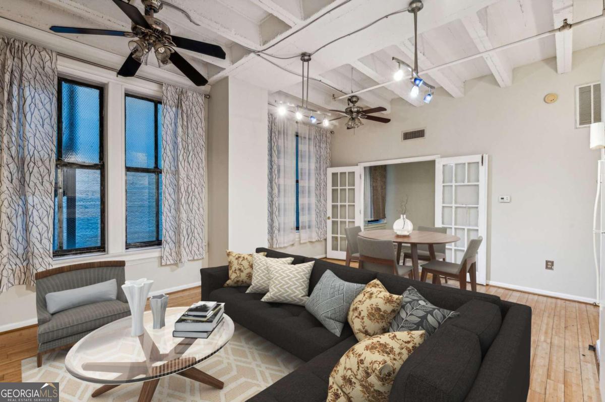 a living room with furniture a ceiling fan and a window