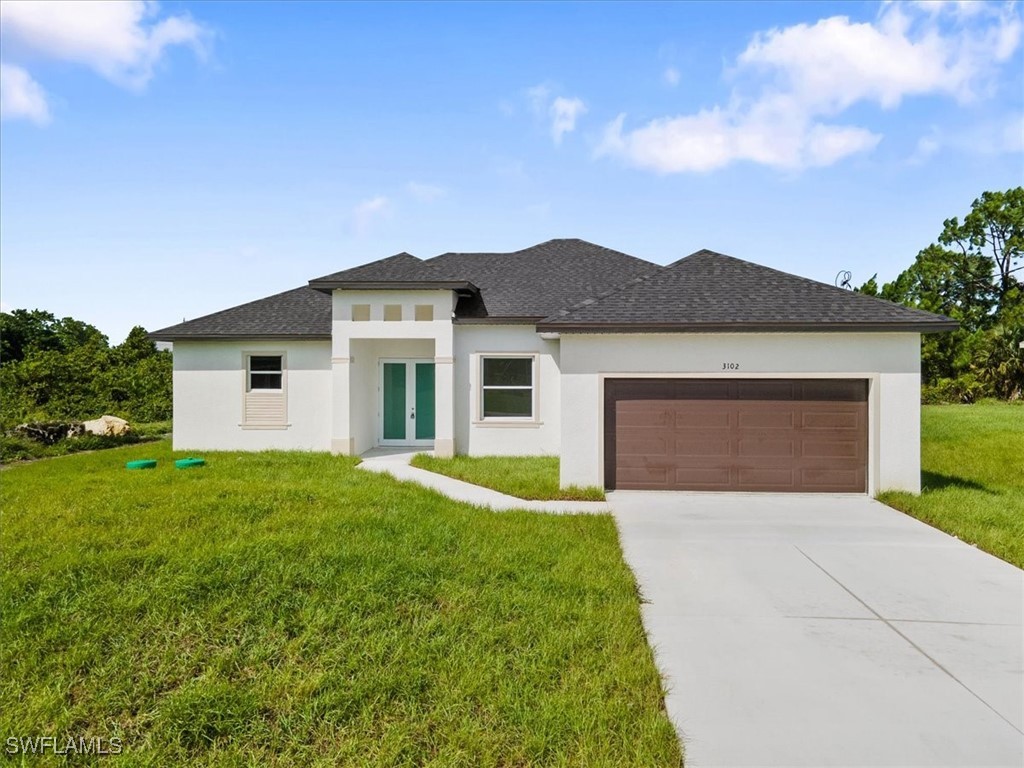 a front view of house with yard and garage