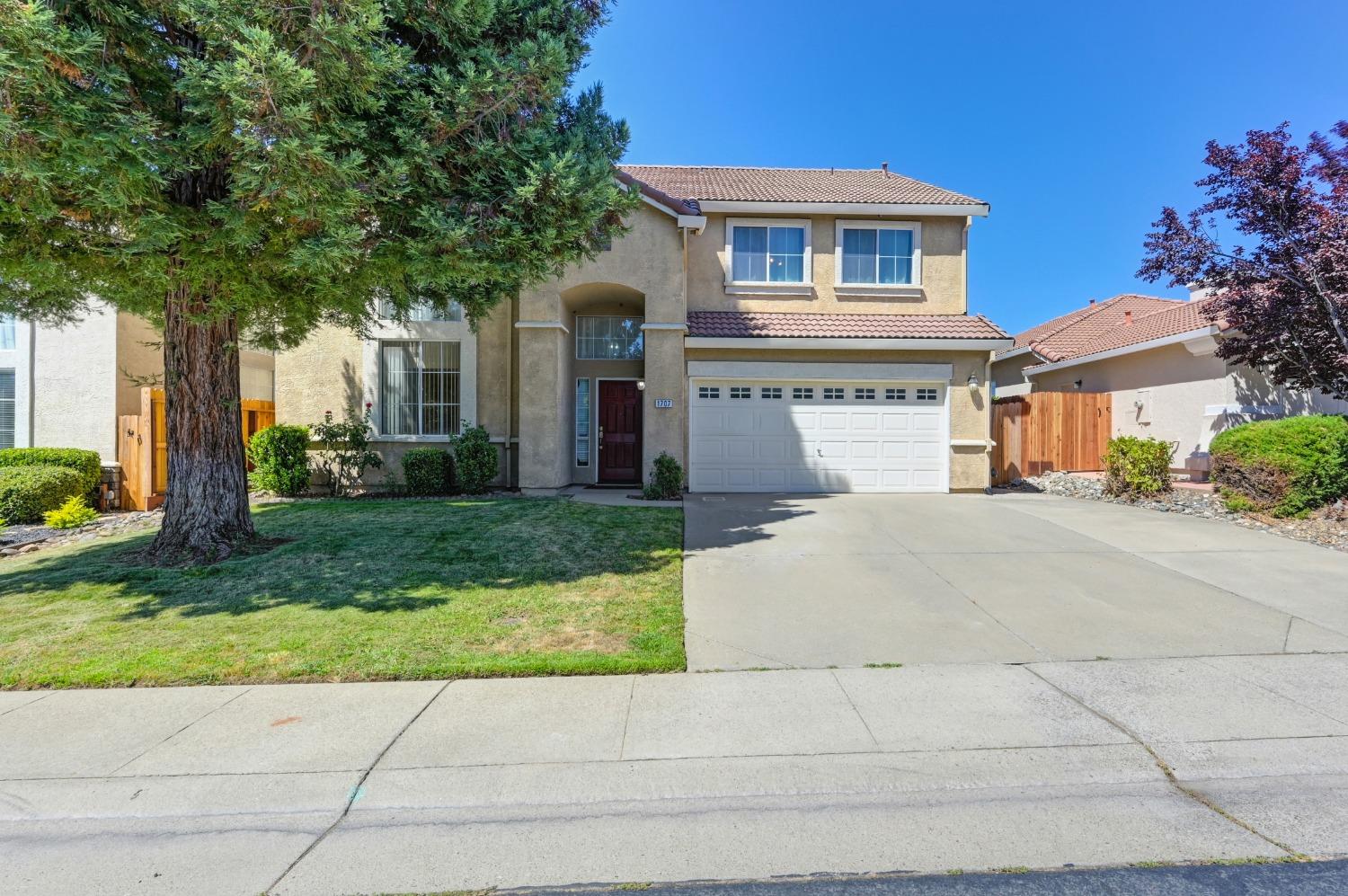 a front view of a house with a yard and garage