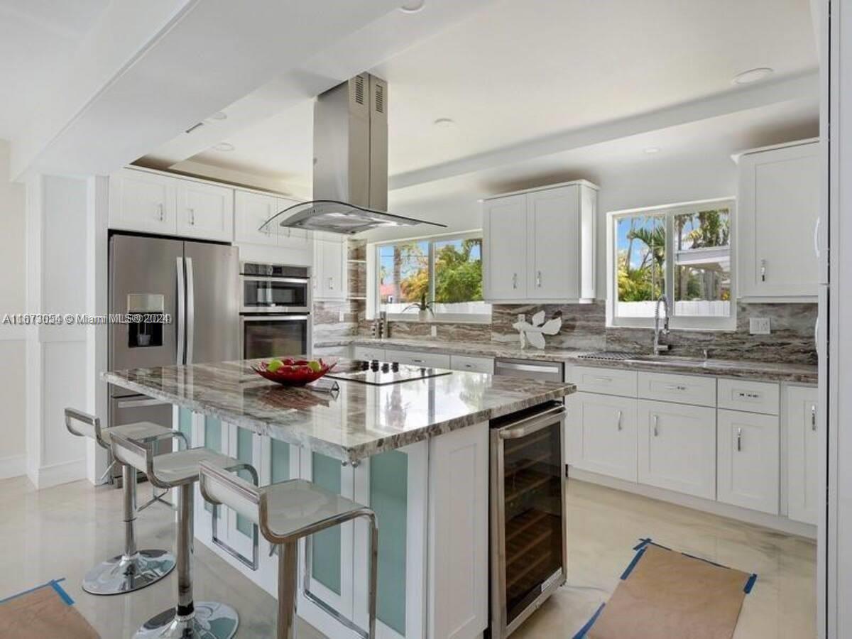 a kitchen with stainless steel appliances granite countertop a stove a sink and a refrigerator