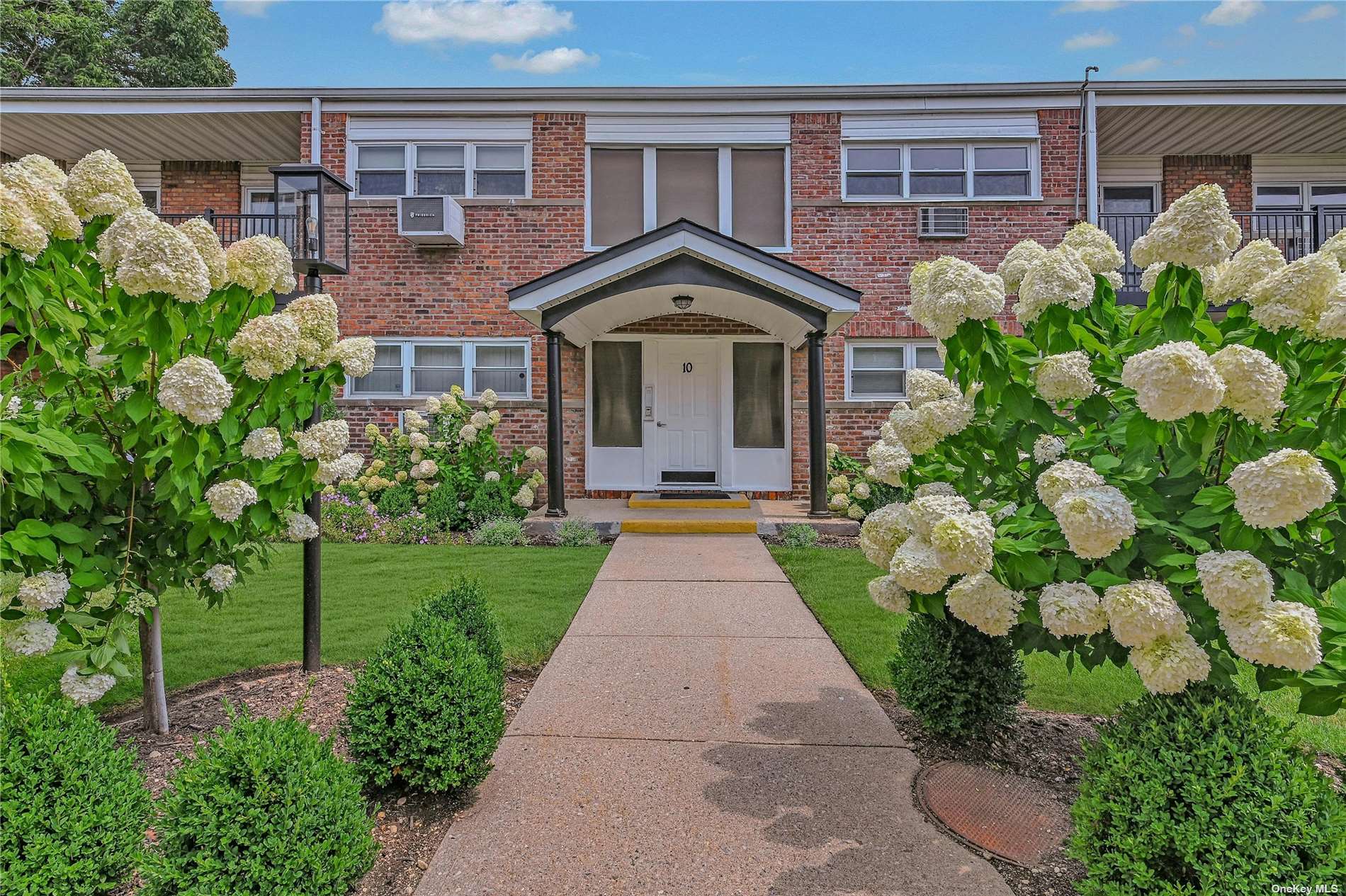 a front view of a house with a yard and flowers