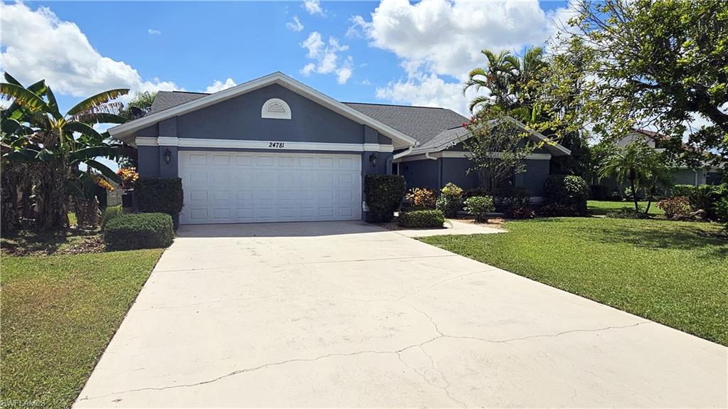 Ranch-style house with a garage and a front lawn