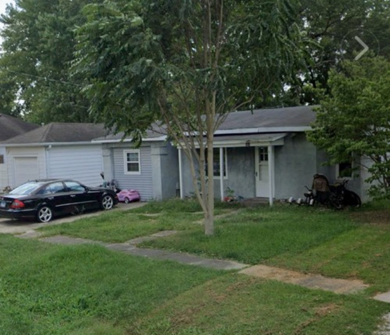 a front view of a house with a garden and trees