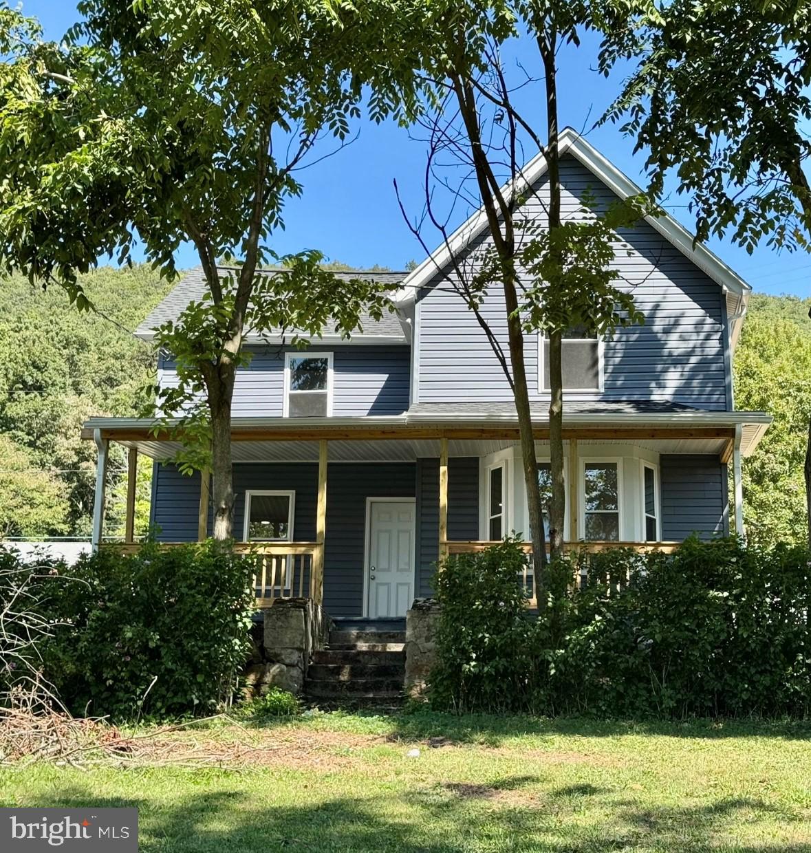 a front view of a house with a yard and potted plants