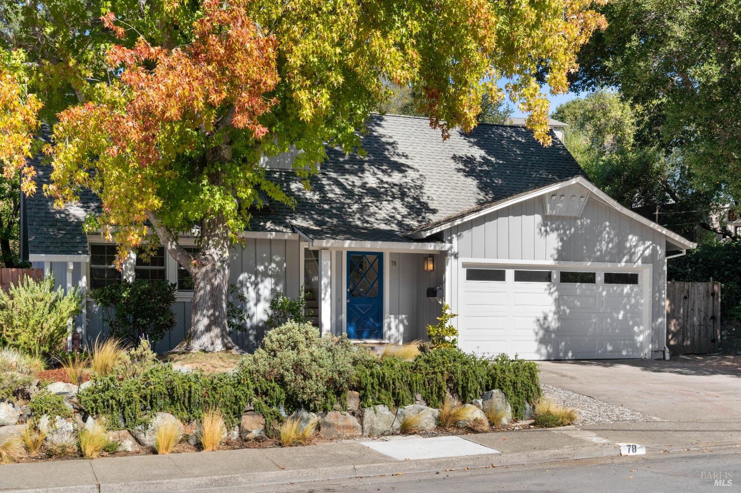 a view of a white house next to a road and yard