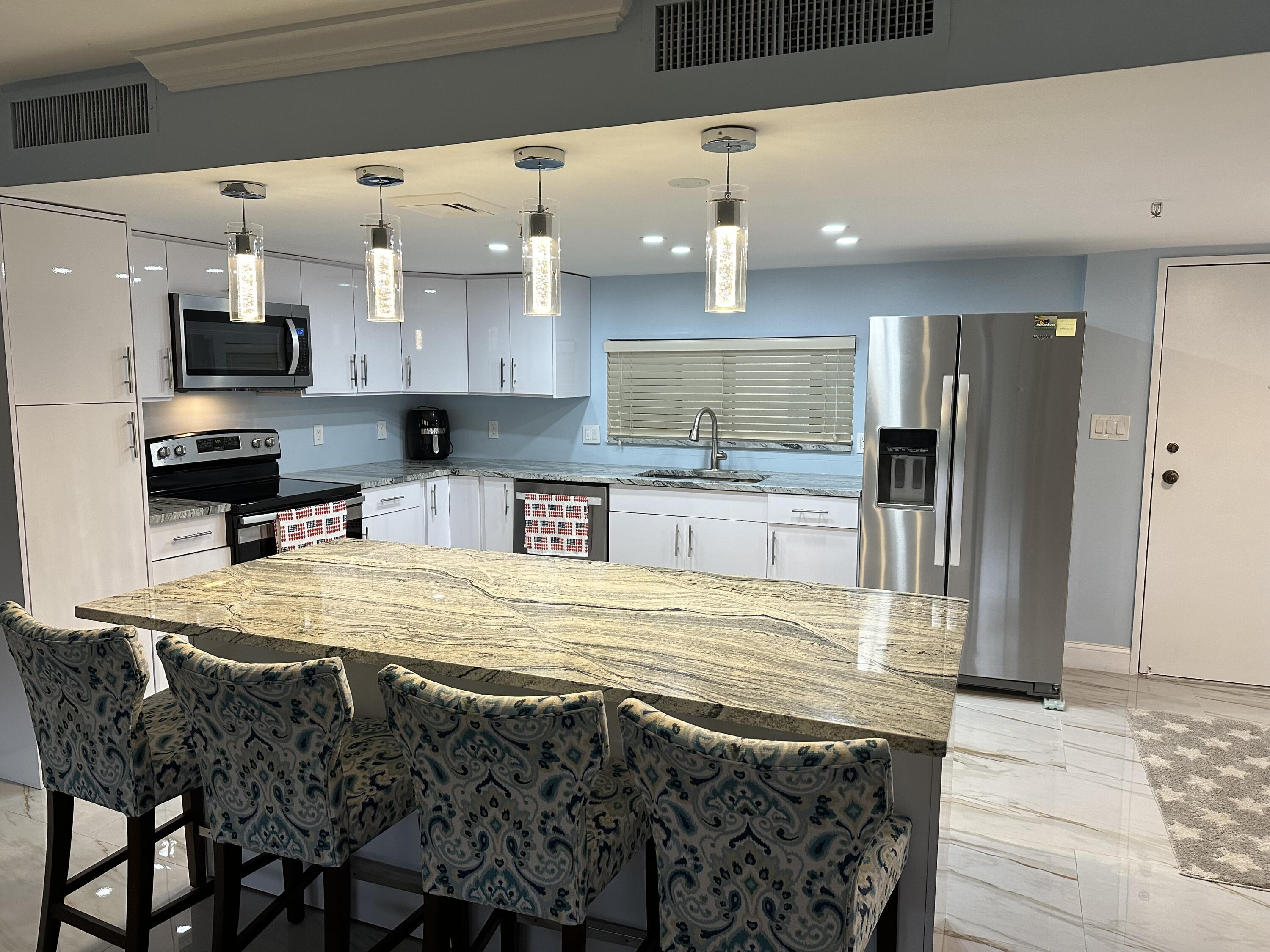 a large kitchen with stainless steel appliances kitchen island granite countertop a sink and cabinets