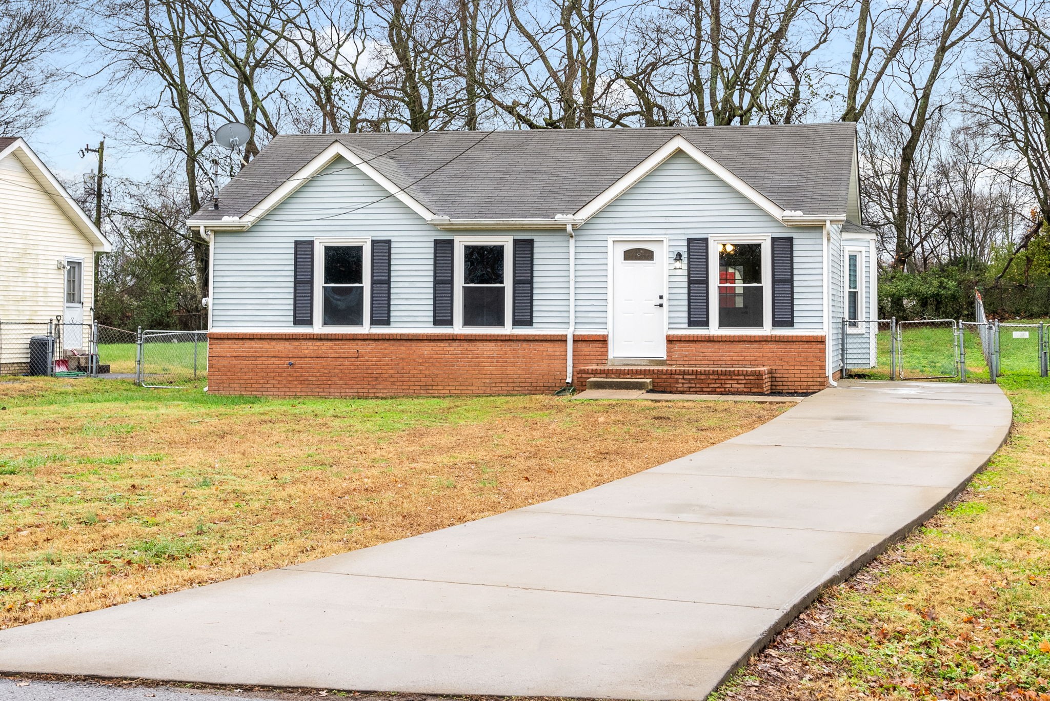 a front view of a house with a yard and trees