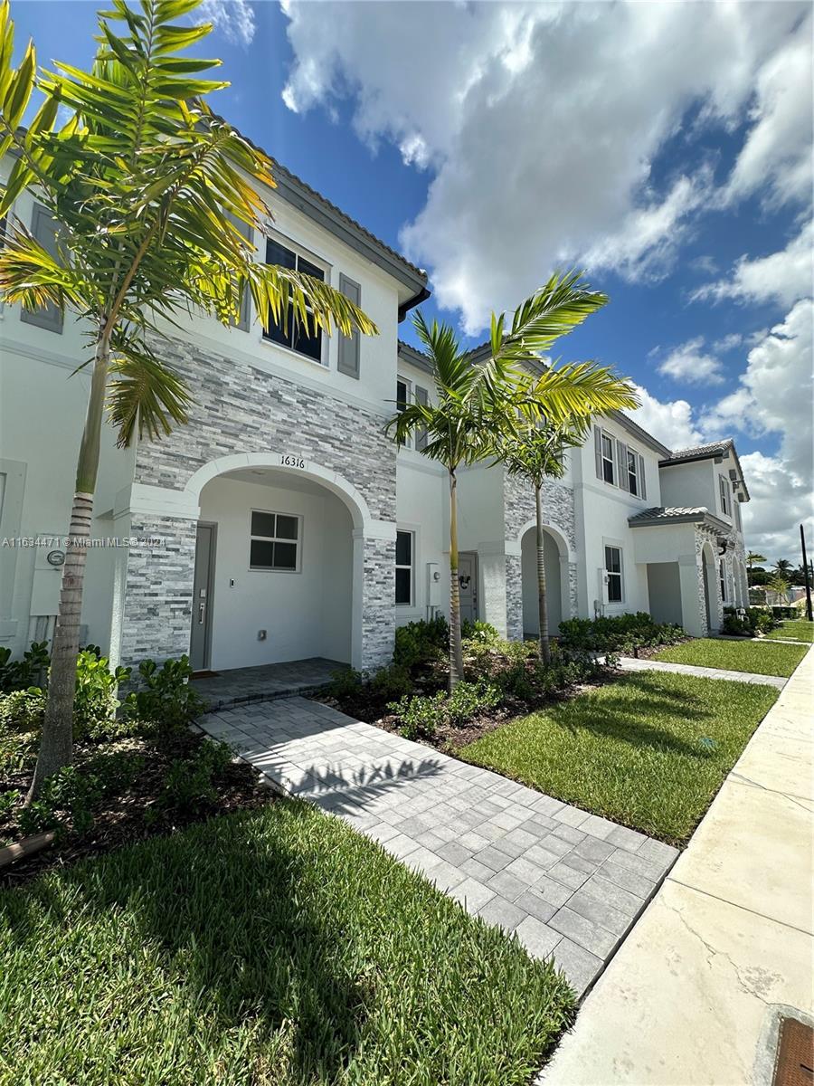 a front view of a house with a garden