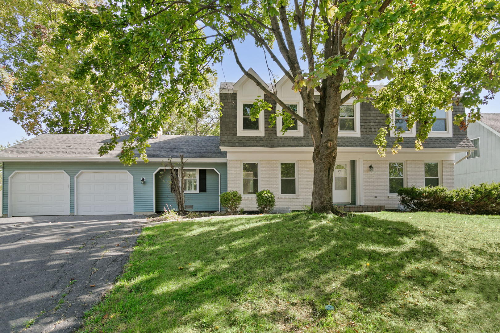 a front view of a house with a yard and trees