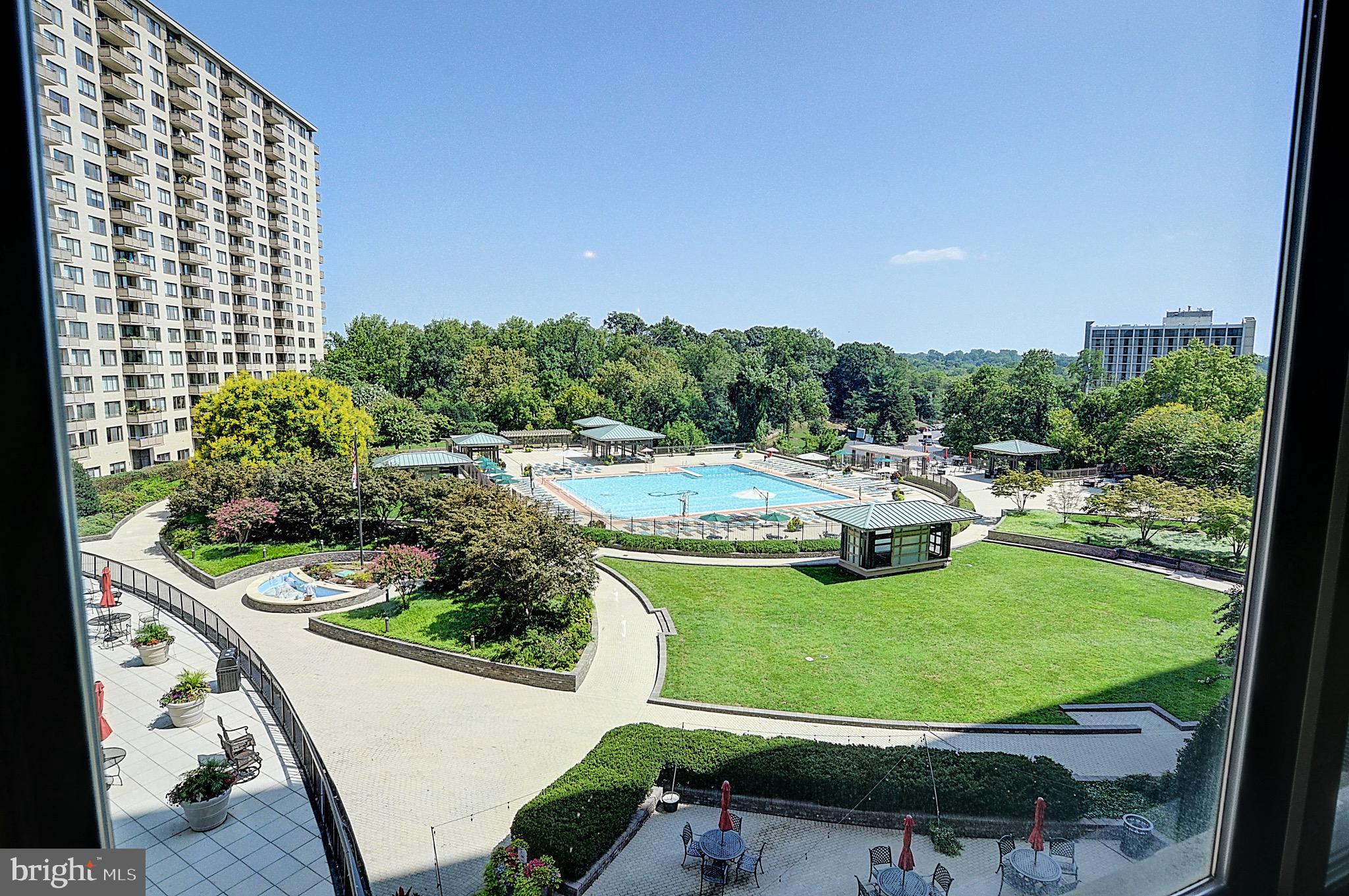 a view of a swimming pool with a yard and outdoor seating