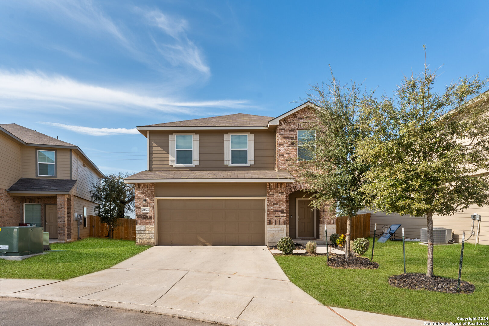 a front view of a house with a yard and a garage