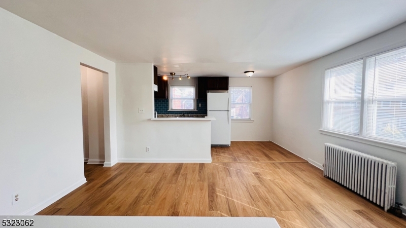 a view of a livingroom with wooden floor and staircase