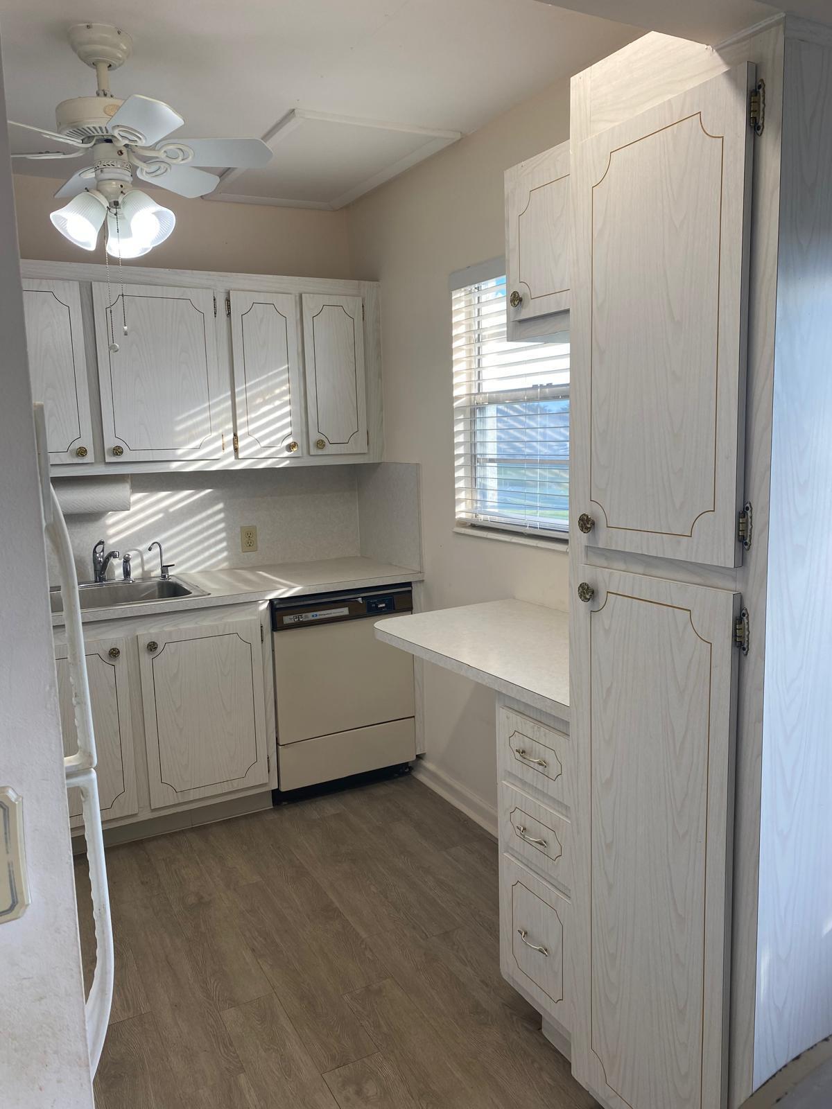 a kitchen with cabinets stainless steel appliances and a window