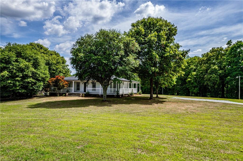 a front view of a house with a yard and trees