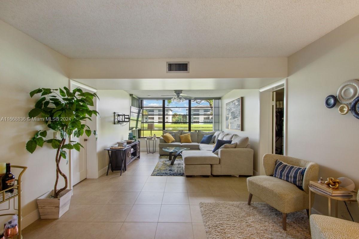 a living room with furniture and a potted plant