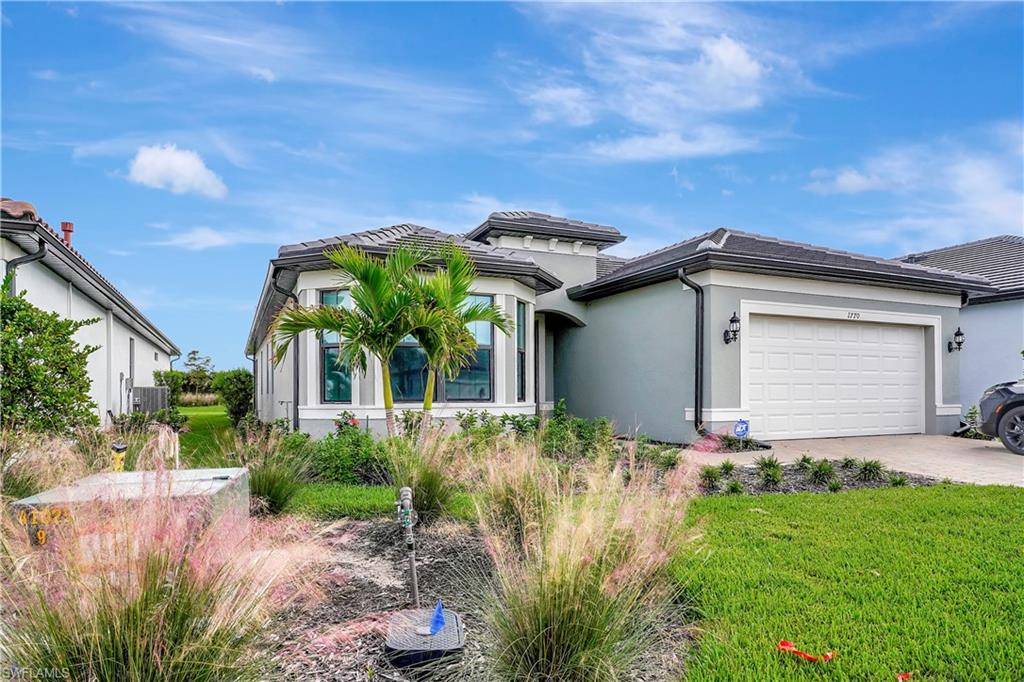 View of front of home featuring a front lawn and a garage