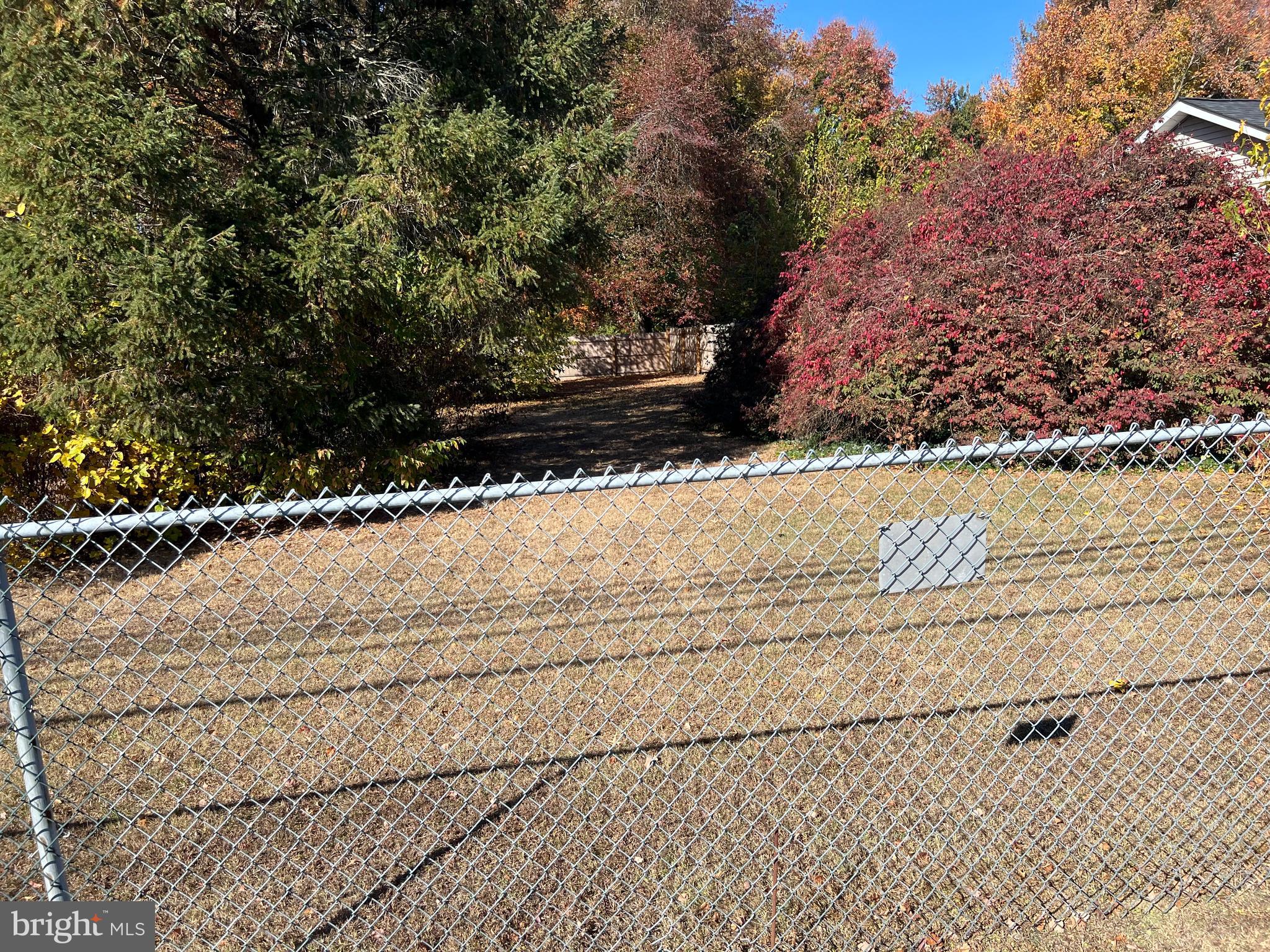 a view of a yard with wooden fence