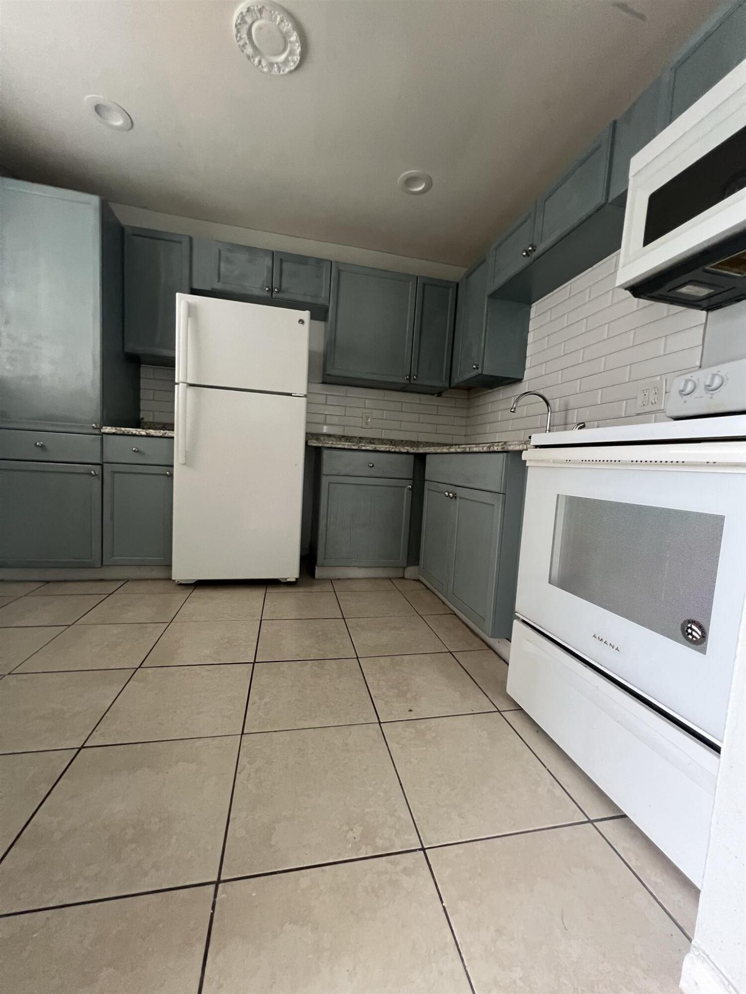 a kitchen with a stove top oven and cabinets