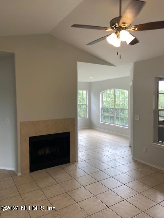 an empty room with windows and fireplace