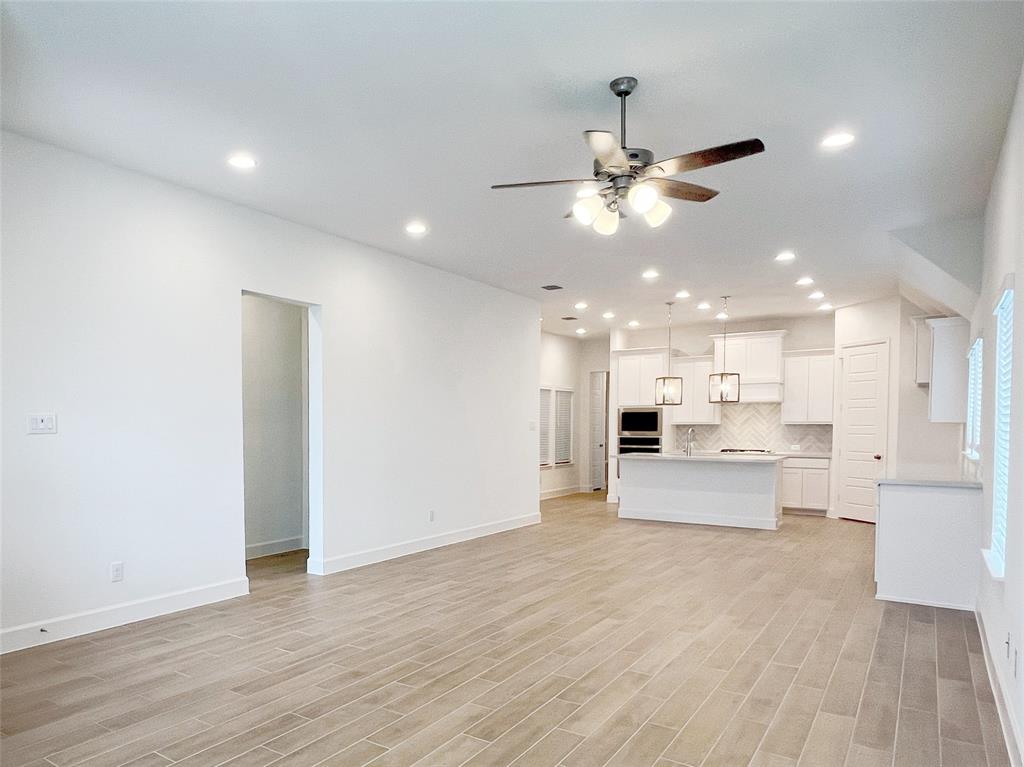 a view of an empty room and kitchen view of a chandelier