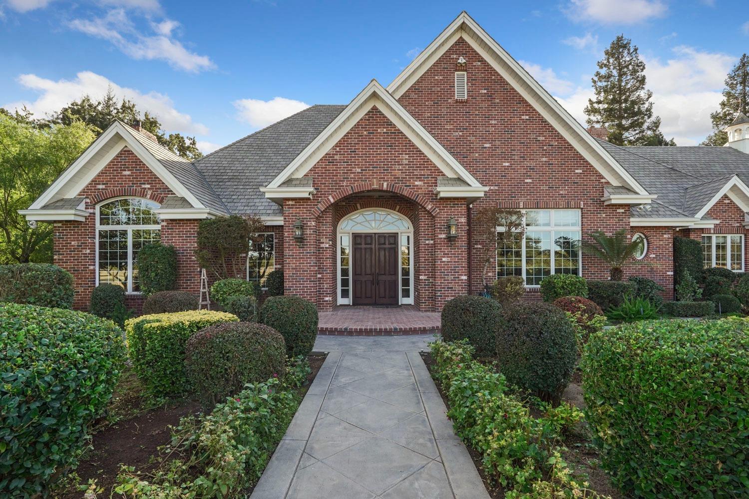 a view of a house with brick walls and a yard