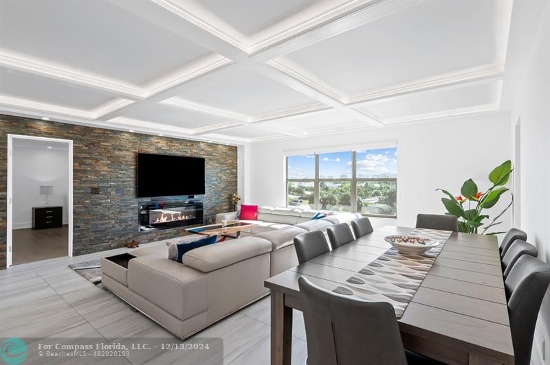 a living room with furniture a flat screen tv and a large window