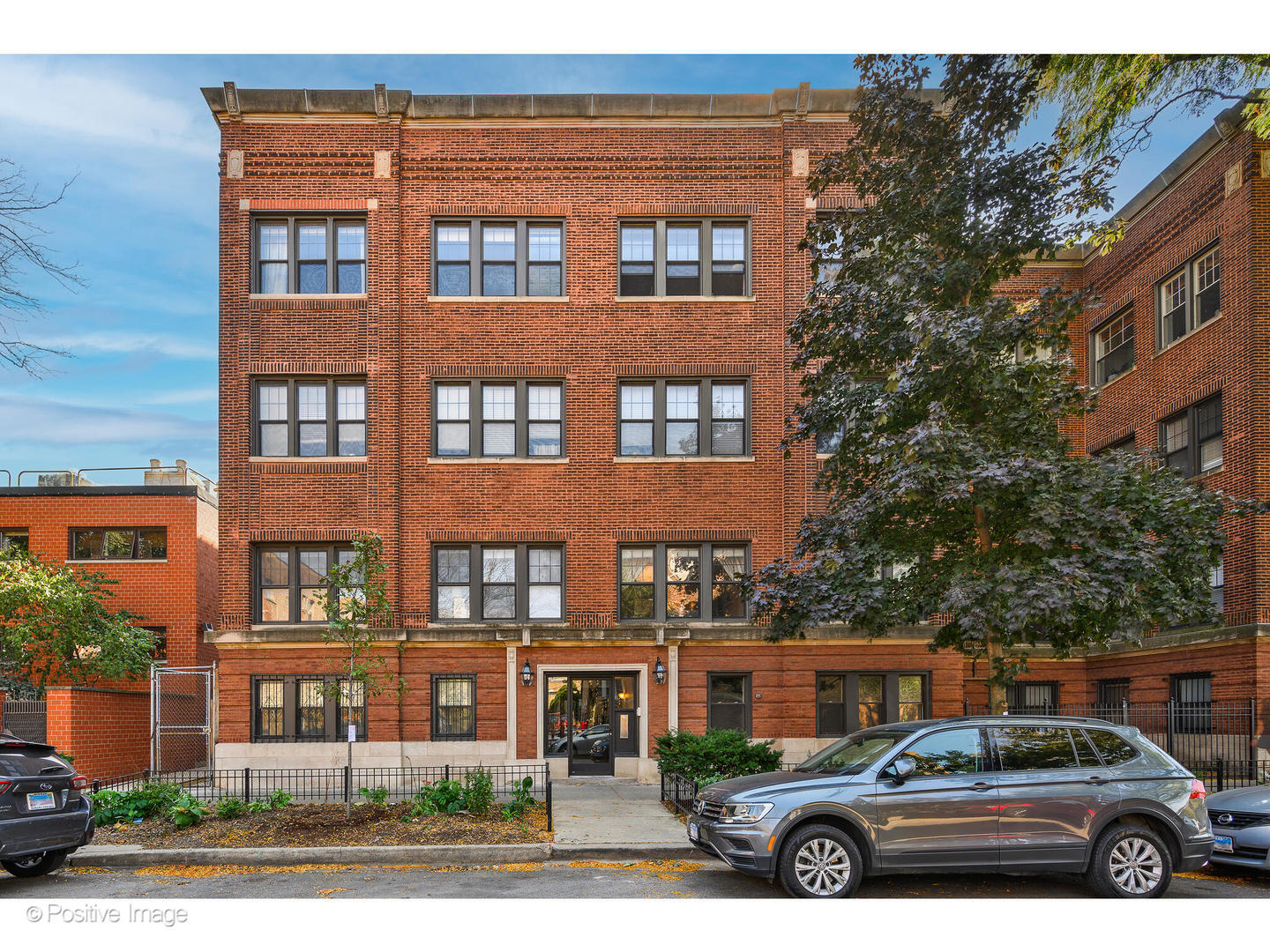 a front view of a residential apartment building with a yard