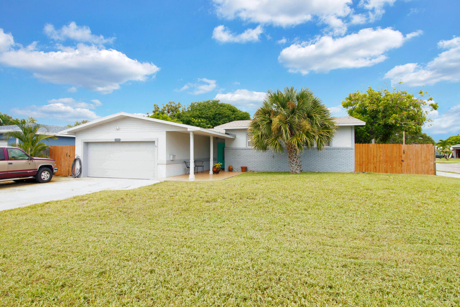 a front view of house with yard and trees in the background