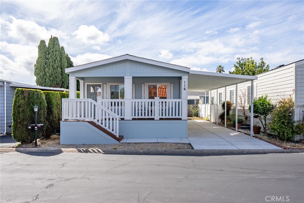 a view of a house with porch and wooden fence