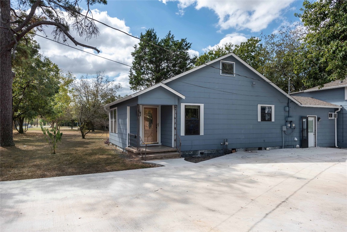 a view of a house with yard and trees in the background