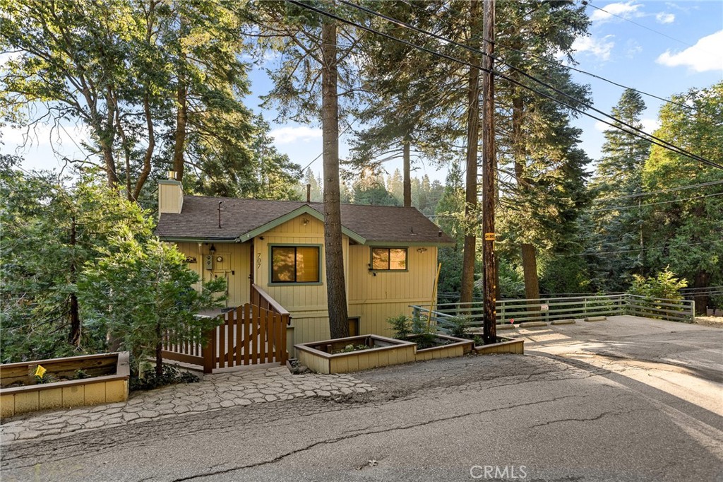 a view of a house with a yard and large tree