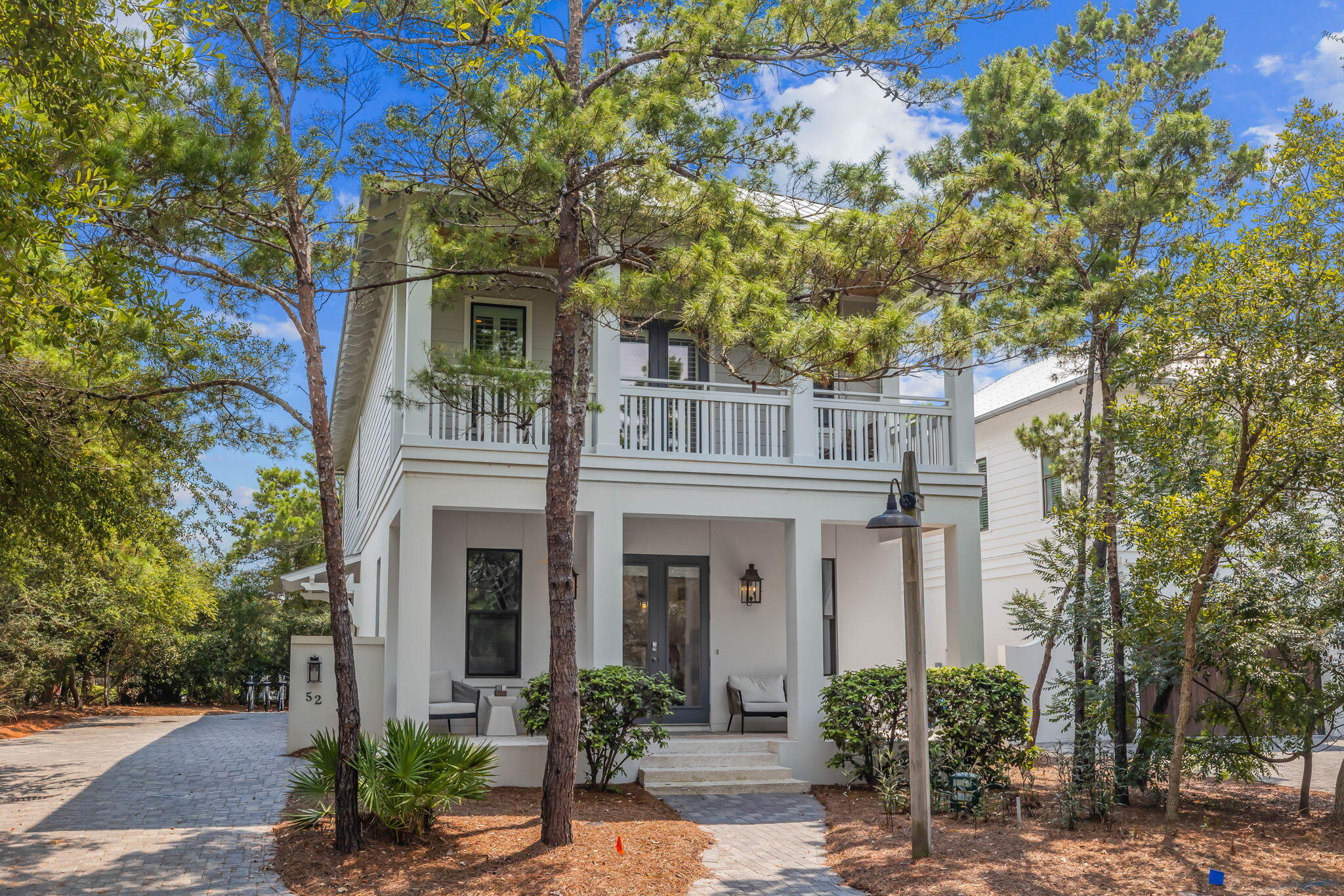 a front view of a house with plants and trees