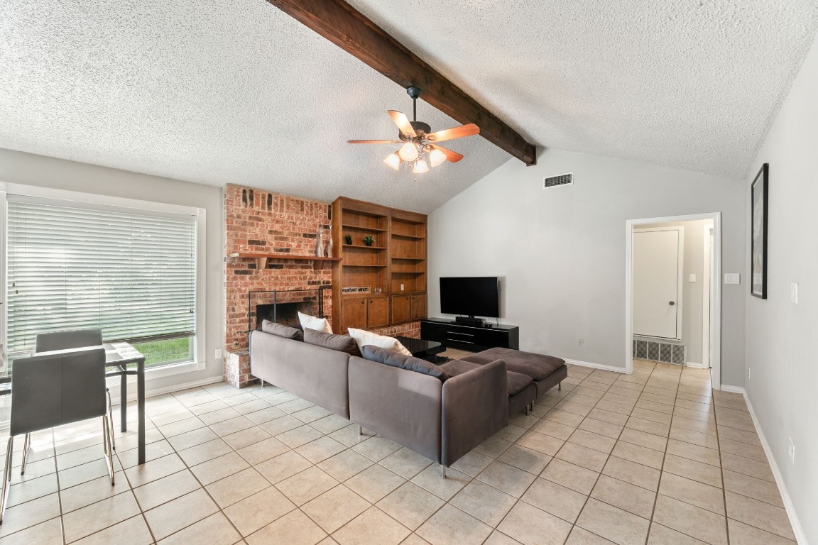 a living room with furniture a flat screen tv and a floor to ceiling window