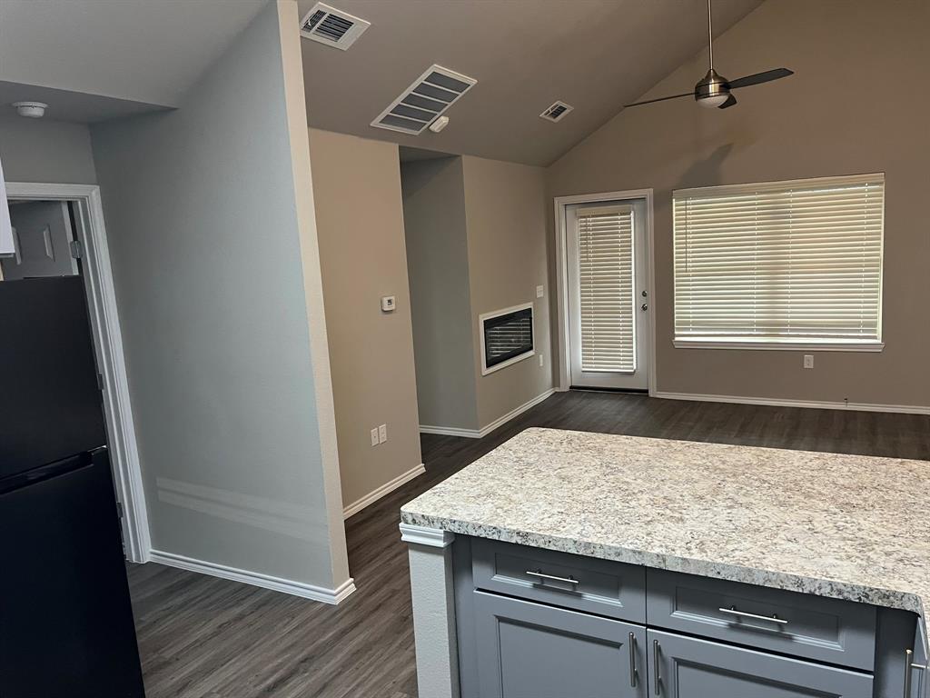 a kitchen with granite countertop cabinets and wooden floor