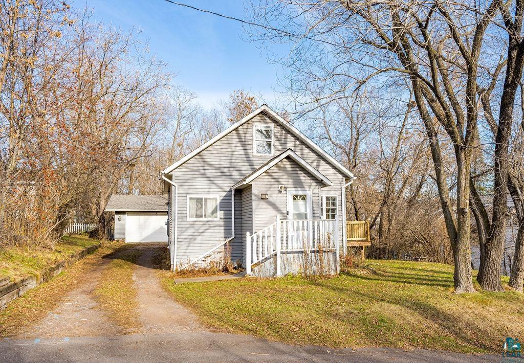 View of front property featuring a front yard, an outdoor structure, and a garage